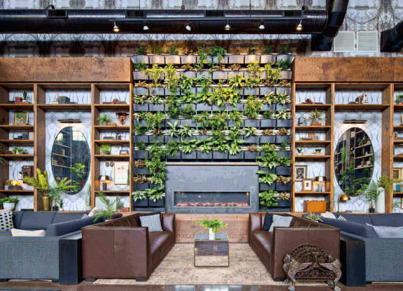 a living room with a fireplace and plants on the wall