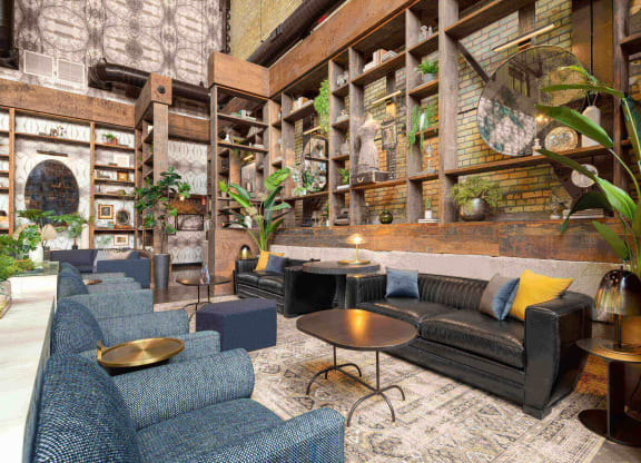 a lobby with couches and chairs and a wall filled with plants