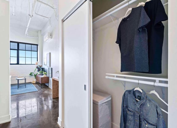 a living room with a closet and a jacket hanging on the wall