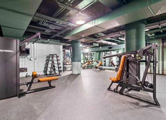 a gym with weights and exercise equipment in a building