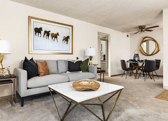 Cozy living room with neutral paint and natural light at Trailgrove Apartments on South Quebec Street in Southeast Denver.