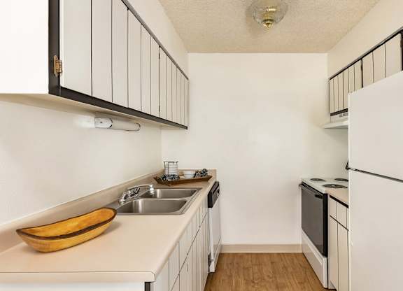 Classic kitchen with white cabinetry and essential appliances at Trailgrove Apartments in Southeast Denver.