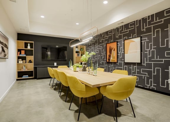 a dining room with a wooden table and yellow chairs