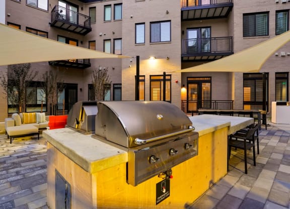 Pet-Friendly Apartments In Wheat Ridge, CO - The Parallel - Grill Area With BBQs, Couches, Tables, And Chairs