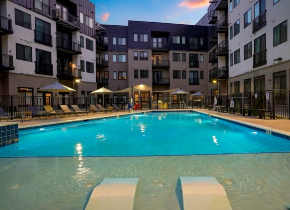 a large swimming pool in front of an apartment building
