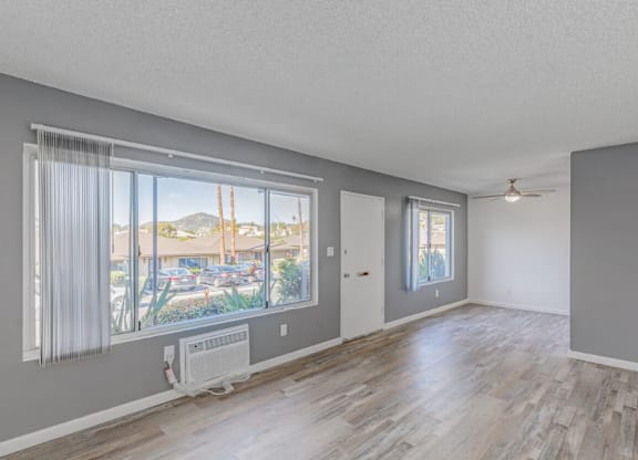 Dog Friendly Apartments in El Cajon CA - Ivanhoe Village - Unfurnished Open-Concept Living Room with Large Window and Sliding Glass Door to Patio