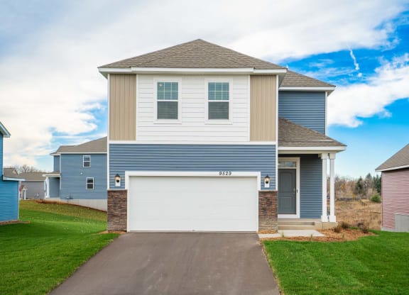 a blue and tan house with a garage door