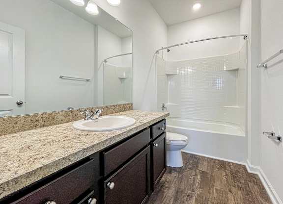 A bathroom with a sink, toilet, and shower.