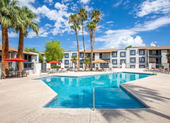 Apartments Tucson, AZ, for Rent - Peaks at Redington - Gated Swimming Pool with Lounge Seats, Tables, Chairs, Umbrellas, and Palm Trees.