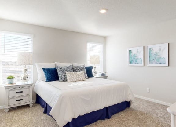 a bedroom with a white bed and blue pillows