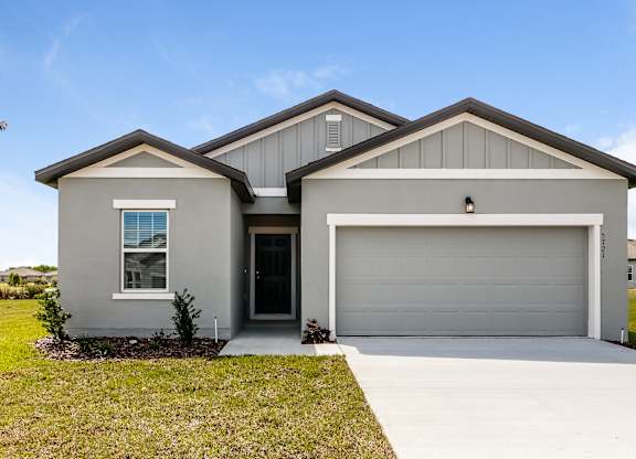 A two-story house with a garage door and a window.