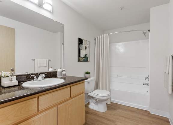 A bathroom with a toilet, sink, and bathtub.