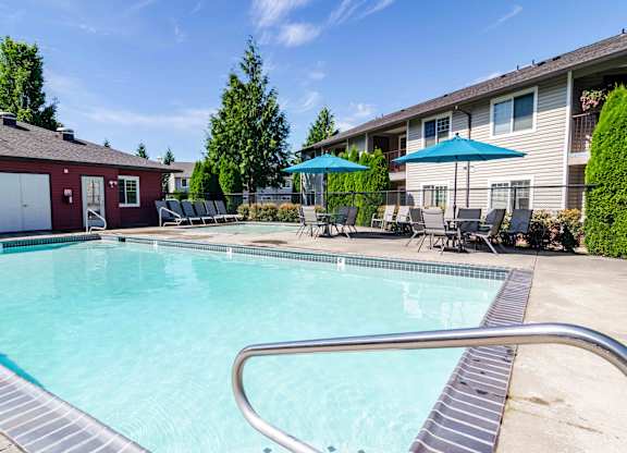 1-Bedroom Apartments in Vancouver, WA - Reflections at the Park - Sparkling Swimming Pool with Wading Pool, Daybeds, Tables, Chairs, And Umbrellas