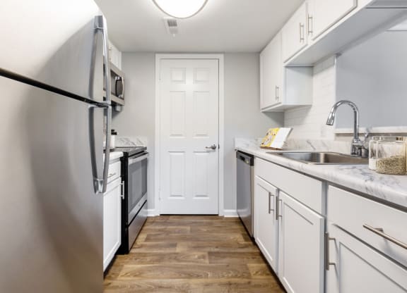 Reserve at Providence Apartment in Charlotte NC photo of a kitchen with white cabinets and stainless steel appliances