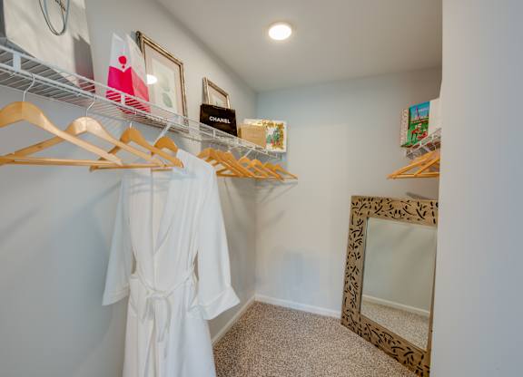 A white dress is hanging on a rack in a room.