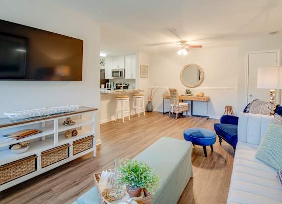 A living room with a white couch and a blue ottoman.