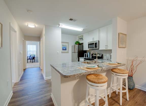 A kitchen with a bar stool and a counter.