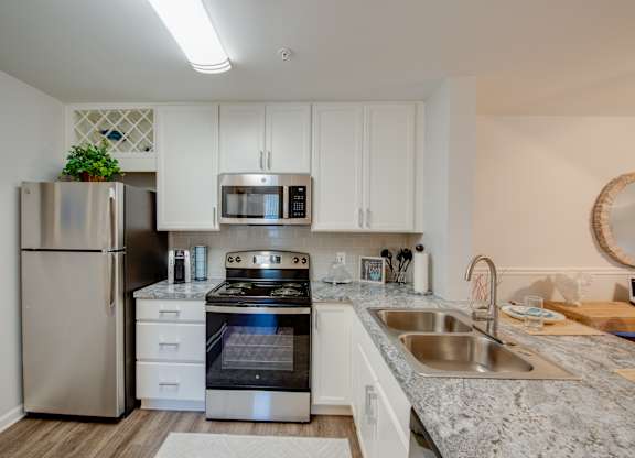 A modern kitchen with stainless steel appliances and white cabinets.
