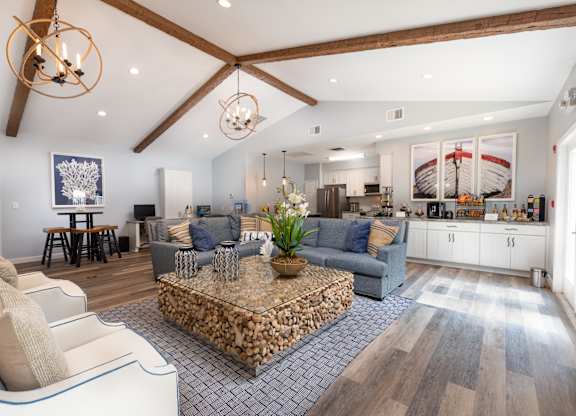 A modern living room with a stone coffee table and a large painting on the wall.