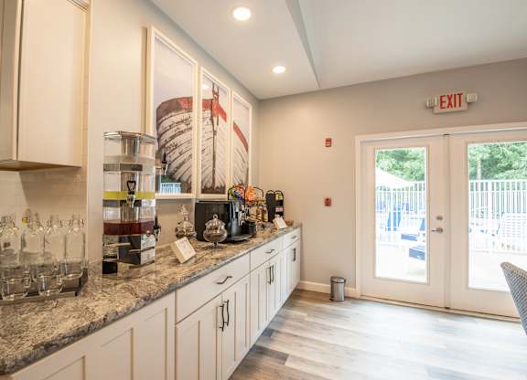 A kitchen with a marble countertop and a view of a waterfall outside the window.