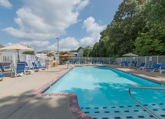 A large outdoor swimming pool with blue water and a red and white checkered border.