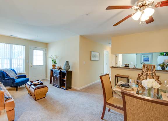 A living room with a blue couch and a fan.