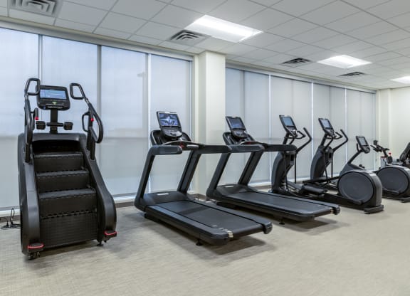 a gym with various cardio equipment and treadmills