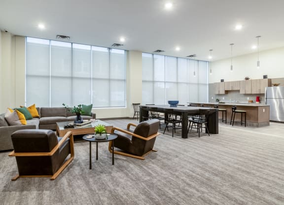a living room with couches and chairs and a kitchen with a table and chairs