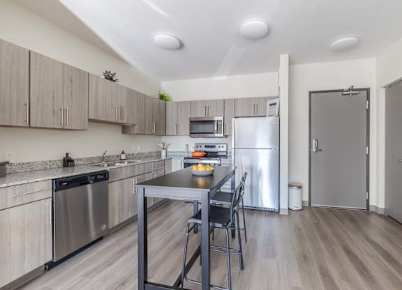 A kitchen with a table and chairs in the middle of the room.