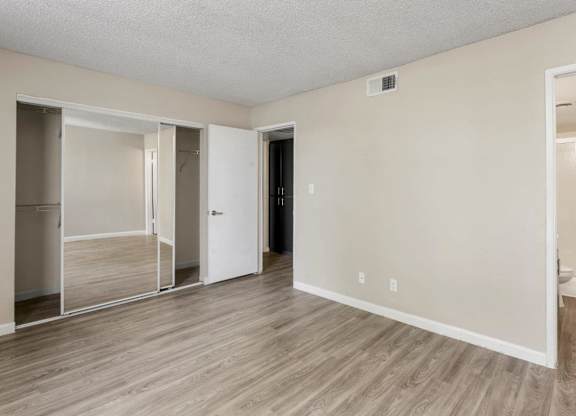 Bedroom with spacious closet featuring mirrored sliding doors at Sentry Tempe apartments in Tempe near Mesa, Arizona