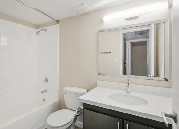 Bathroom with tub, shower, and large mirror at Sentry Tempe apartments in Tempe near Mesa, Arizona
