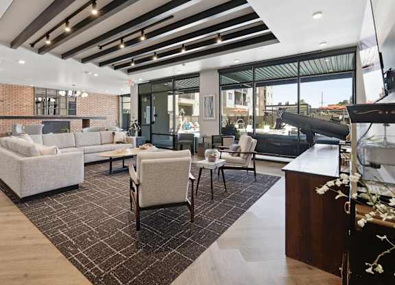 A modern living room with a brick wall and a large window.