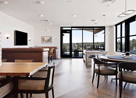 A modern dining room with a wooden table and chairs.