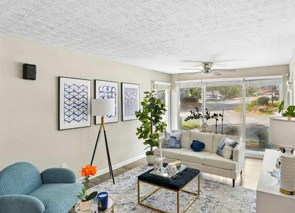 A living room with a blue chair and a white couch.