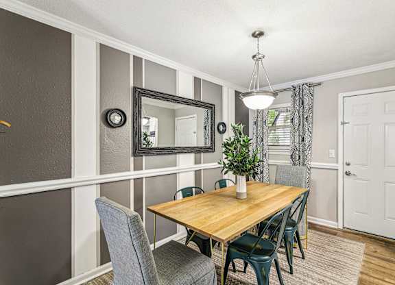 A dining room with a wooden table and grey chairs.