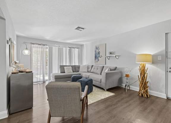 A living room with a grey couch and a chair.