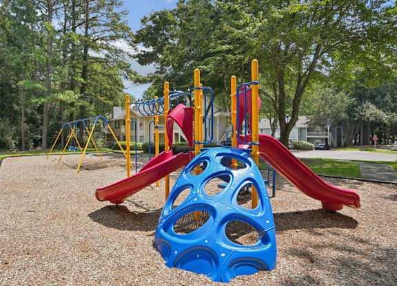 A playground with a blue and red slide and a yellow structure.