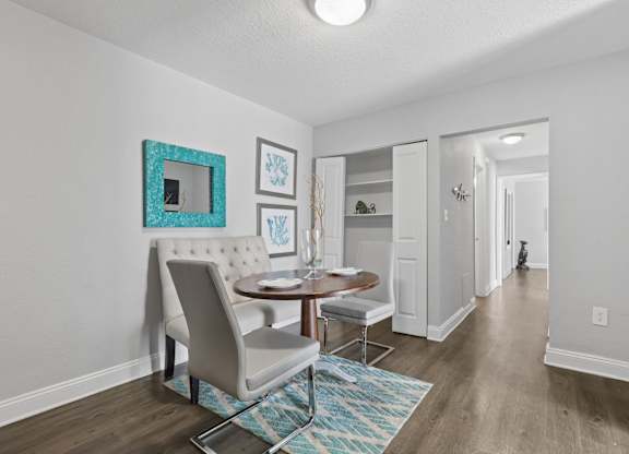 A dining room with a table and chairs.