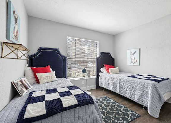 A bedroom with two beds and a window.