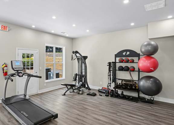 A gym room with a treadmill, weights, and exercise equipment.
