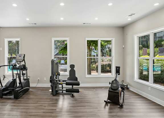 A spacious home gym with treadmills, a stationary bike, and a rowing machine.
