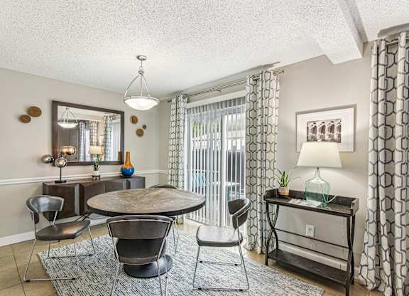 A living room with a round table and chairs.