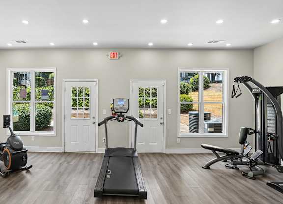 A spacious gym with a treadmill, elliptical machines, and other exercise equipment.