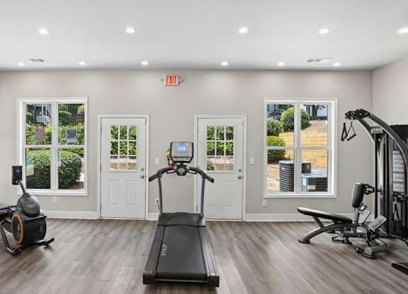 A spacious home gym with a treadmill, elliptical trainer, and stationary bike.
