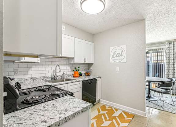 A kitchen with a marble countertop and a sign that says
