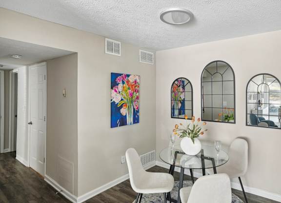 A dining room with a glass table and chairs.