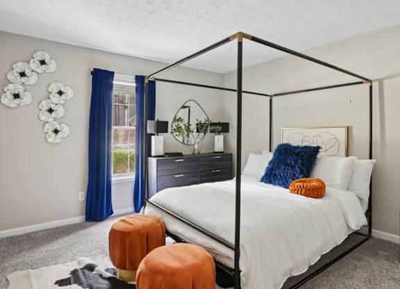 A bedroom with a white bed and a black metal frame.