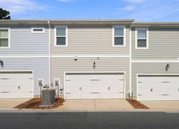 A row of houses with garages and driveways.