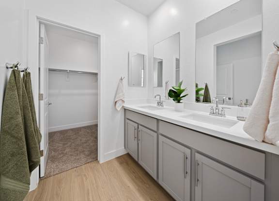 A bathroom with a green towel hanging on the door.