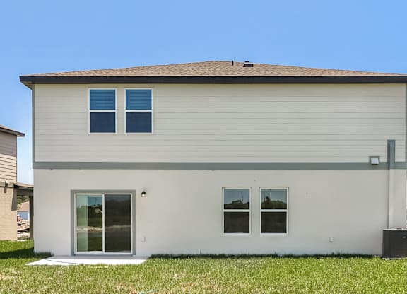A small house with a grey roof and white walls.